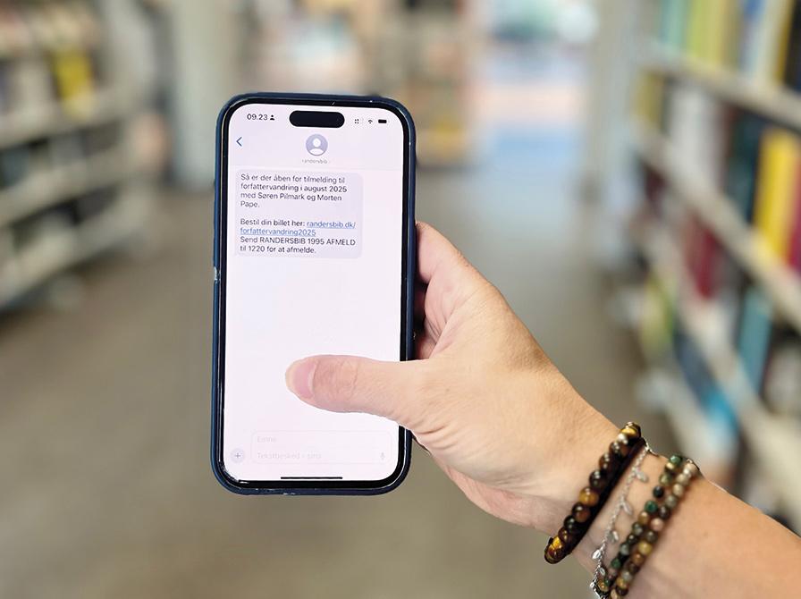 Hånd der holder en mobiltelefon med en sms på skærmen